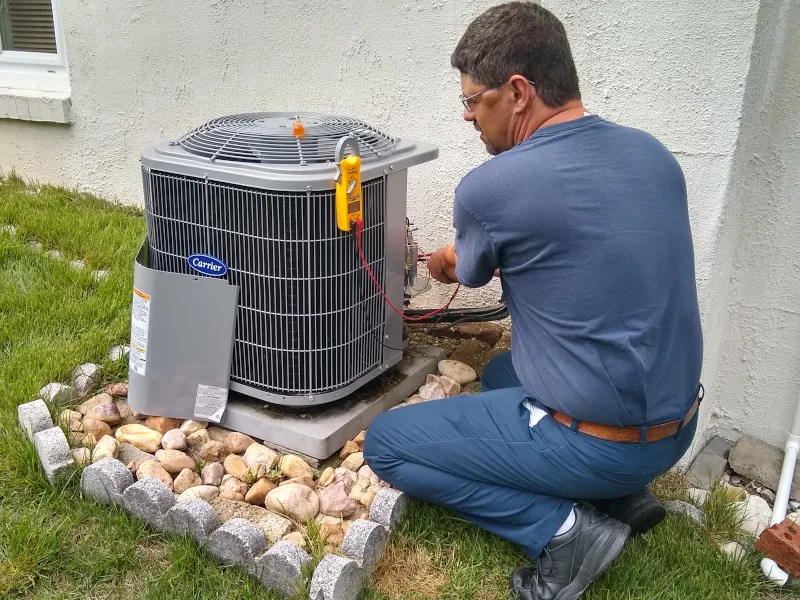 Delta Service technician working on an AC unit outside.